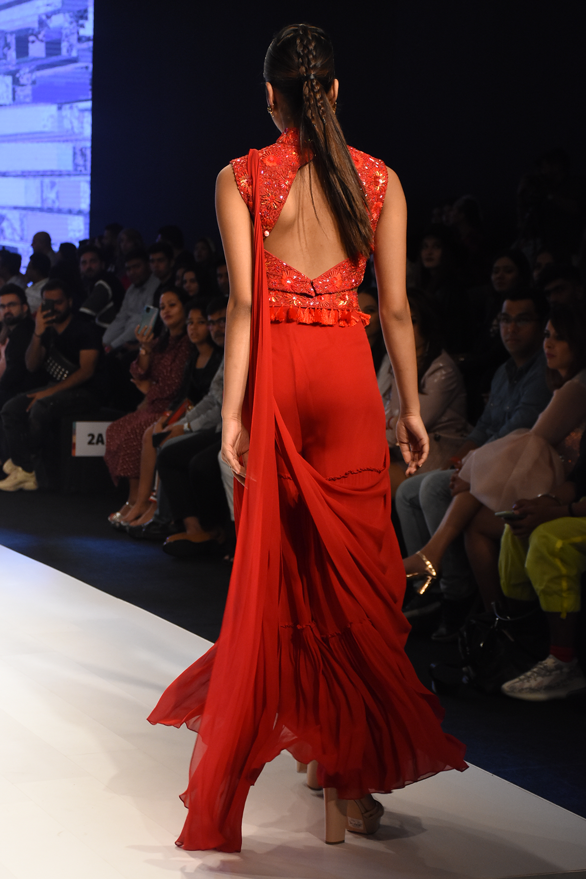 RED PRESTITCHED TIERED PANTS SAREE WITH SELF ON SELF 3D EMBROIDERED HIGH NECK BLOUSE & EMBROIDERED TASSEL BELT