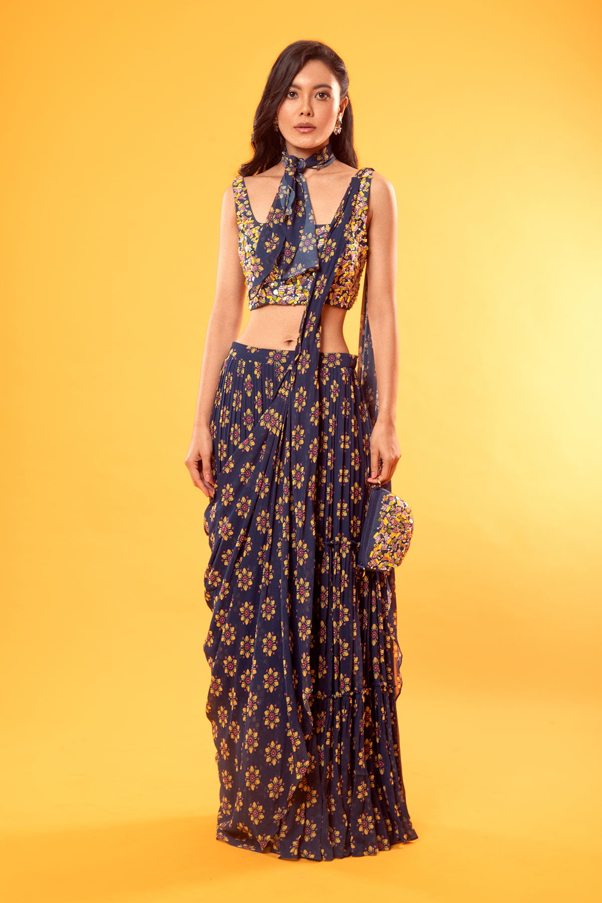 BLUE TRIGONAL EMBROIDERED BLOUSE WITH FLORAL PRINTED TIERED SKIRT SAREE & EMBROIDERED POTLI BAG