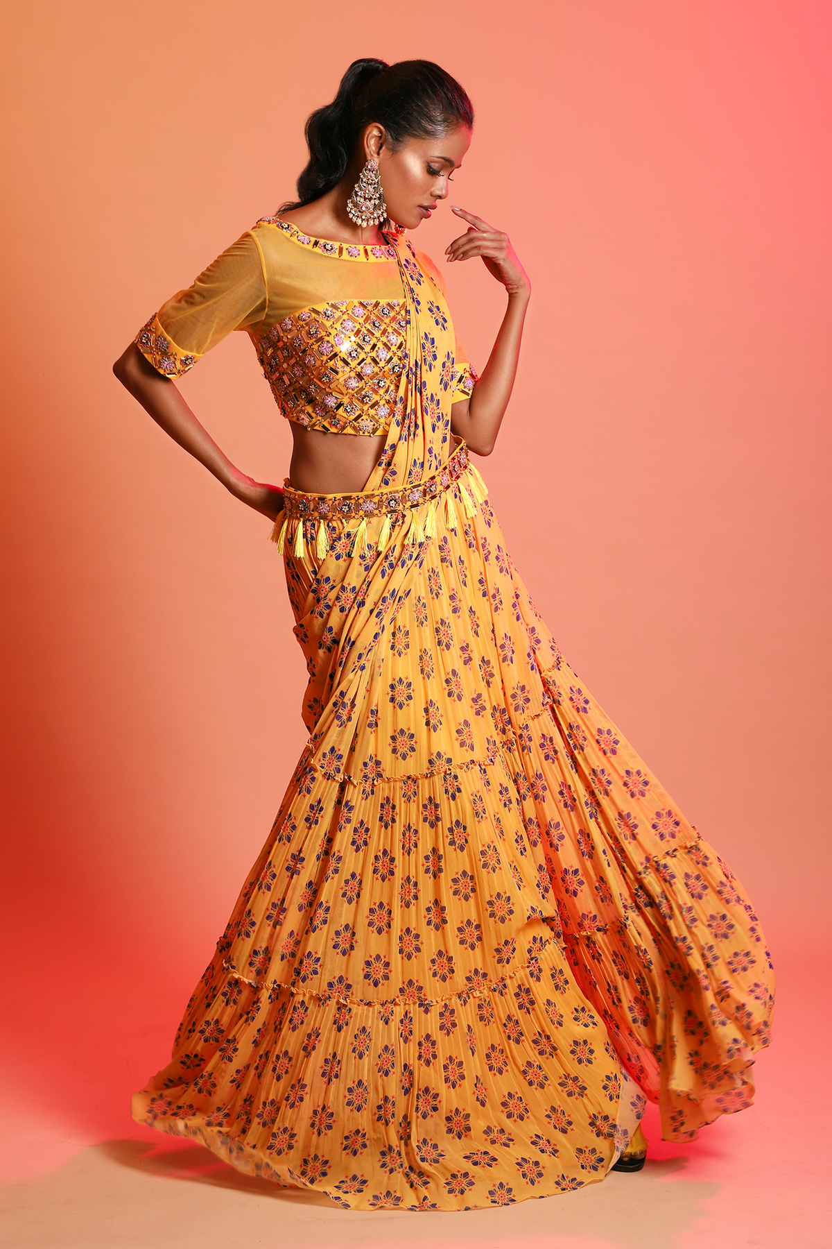 MUSTARD ARYLIC EMBROIDERED BLOUSE & MUSTARD FLORAL PRINTED TIERED SKIRT SAREE WITH EMBROIDERED TASSEL BELT