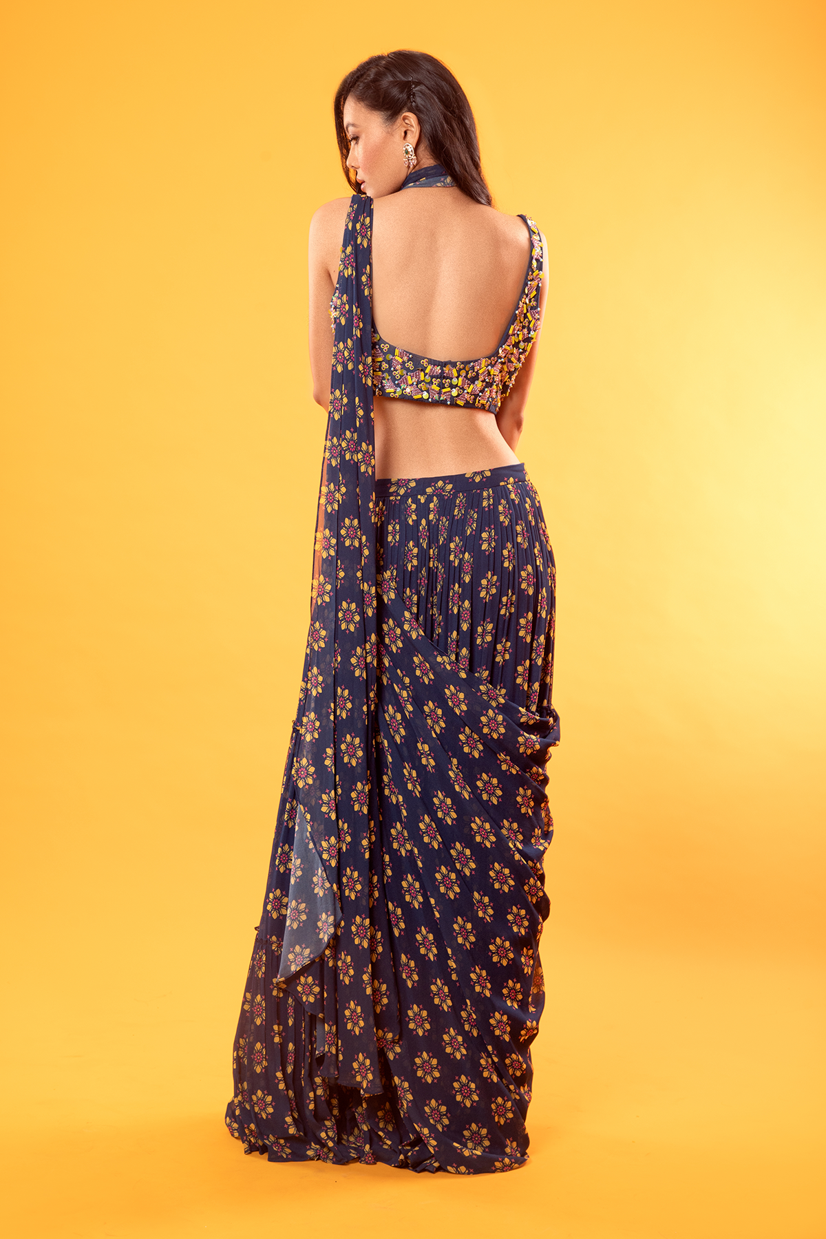 BLUE TRIGONAL EMBROIDERED BLOUSE WITH FLORAL PRINTED TIERED SKIRT SAREE & EMBROIDERED POTLI BAG